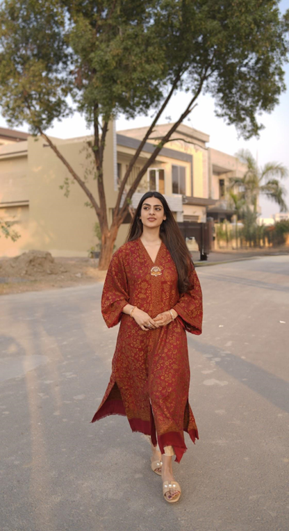 Rust red Sultani kaftan dress with handcrafted gold brooch on neckline and side slits.